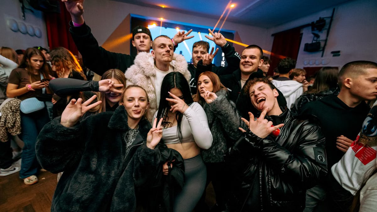 Energetic gathering of young adults celebrating indoors, capturing vibrant party vibes with friends.