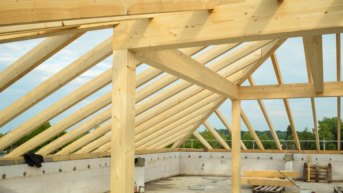 Wooden trusses structure in an unfinished building highlighting construction progress.